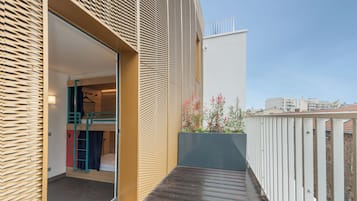 Un appartement moderne doté d’un balcon, d’une porte en bois et offrant une vue sur le paysage urbain.