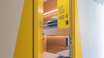 Une porte jaune avec une pancarte indiquant qu’il y a un lit et portant le numéro de la chambre.