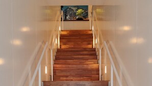 A wooden staircase with white railings and recessed lighting. - Ace Hotel Seattle (Seattle)