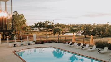 Una piscina al aire libre, sillones reclinables de piscina