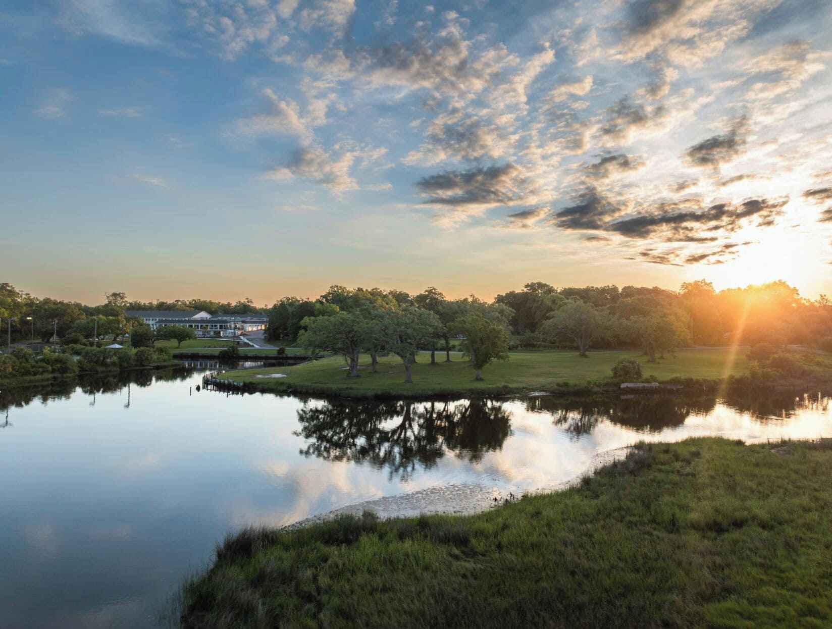 A serene lakeside view with a building in the background.