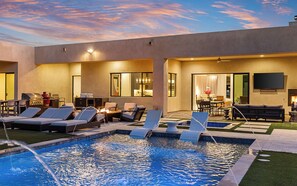 Un espace piscine aménagé avec des chaises longues, un barbecue et un coin repas offrant une vue sur la piscine.