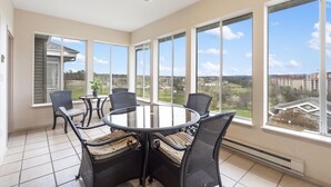 A sunlit room with a round table and chairs, large windows, and a ceiling fan. - Family Getaway • Spacious 3BR Condo • Resort Amenities + Perks (Branson)