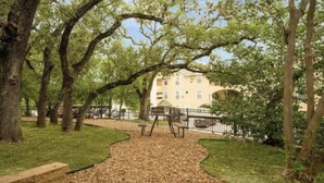 A park with a playground, a building in the background, and a clear sky. - Amazing, Contemporary, Beautiful, Peaceful, and Perfectly Located Property (San Antonio)