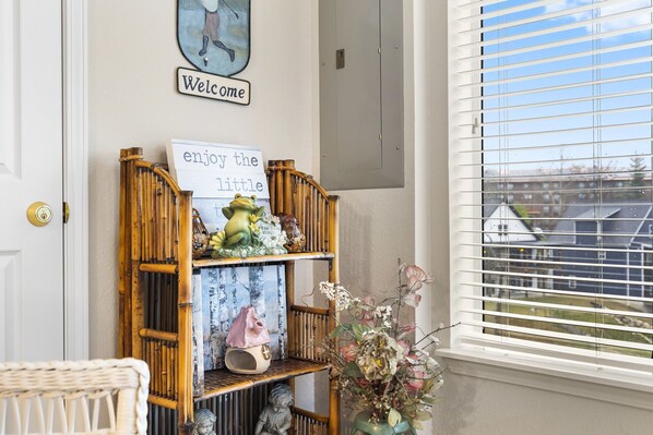 A welcome sign, a small shelf with decorative items, and a window with blinds. - Scenic 2BR Golf Condo • Sunroom • Close to Branson Strip (Branson)