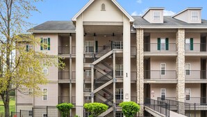 A multi-story apartment building with a central staircase, balconies, and a stone facade. - 2 King Suites • Golf Course Condo • Minutes to Branson Shows & Attractions (Branson)