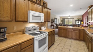 A kitchen with wooden cabinets, a microwave, stove, and a coffee maker. - 2 King Suites • Golf Course Condo • Minutes to Branson Shows & Attractions (Branson)