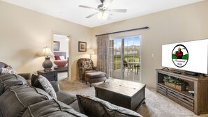 A living room with a sofa, coffee table, and TV on a stand. - 2 Bedroom, 2 Bathroom Walk-in Golf Condo with Private, Covered Balcony (Branson)