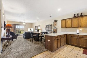 A spacious kitchen with wooden cabinets, a large island, and a dining area with a table and chairs.