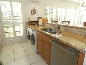 Enjoy cooking in this well-equipped kitchen with a granite countertop, stainless steel appliances, and a large window.