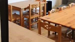 A dining area with a long wooden table and chairs, a television, and a framed picture on the wall. - Homerez - Apartment in Allevard (Allevard)