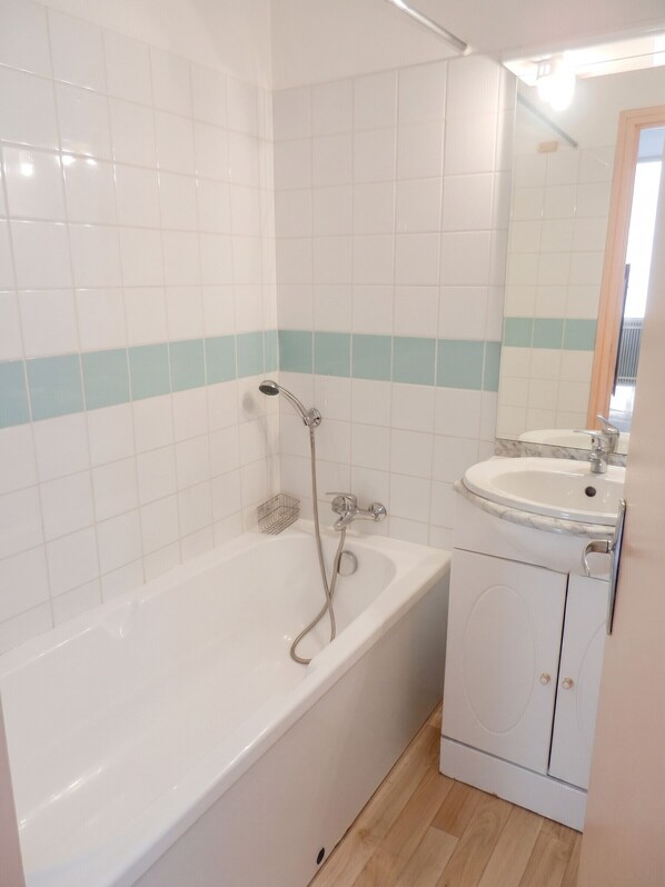 Un baño con bañera, ducha y lavamanos.