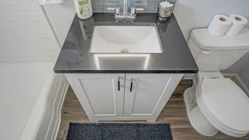 Un baño con un lavamanos blanco, un inodoro y un armario.