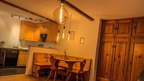 A cozy dining area with wooden furniture, a chandelier, and a wooden cabinet.