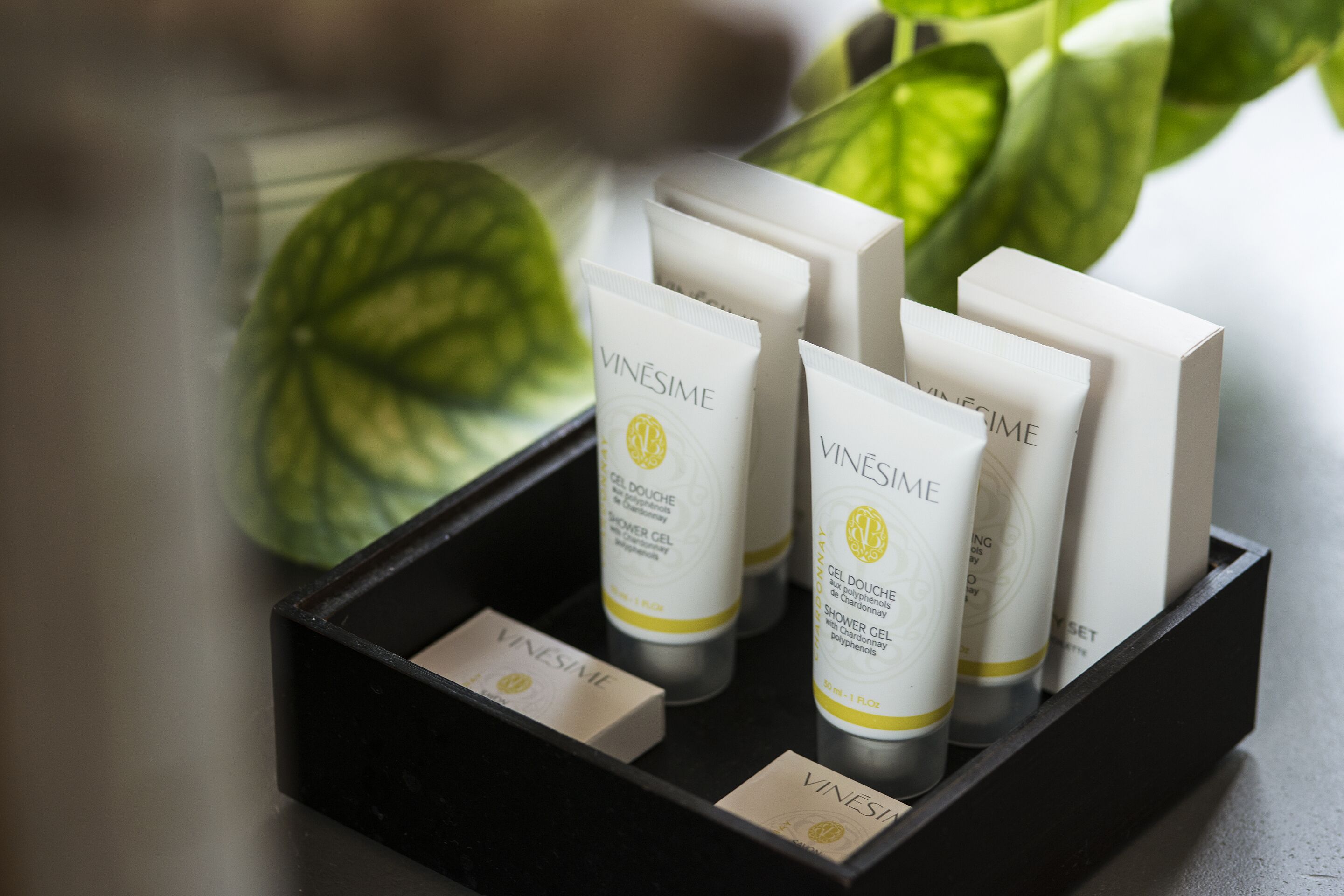 A black tray holding several white tubes with yellow labels, each labeled 'VINESIME' and 'GEL DOUCHE aux polyphénols de Chardonnay.'