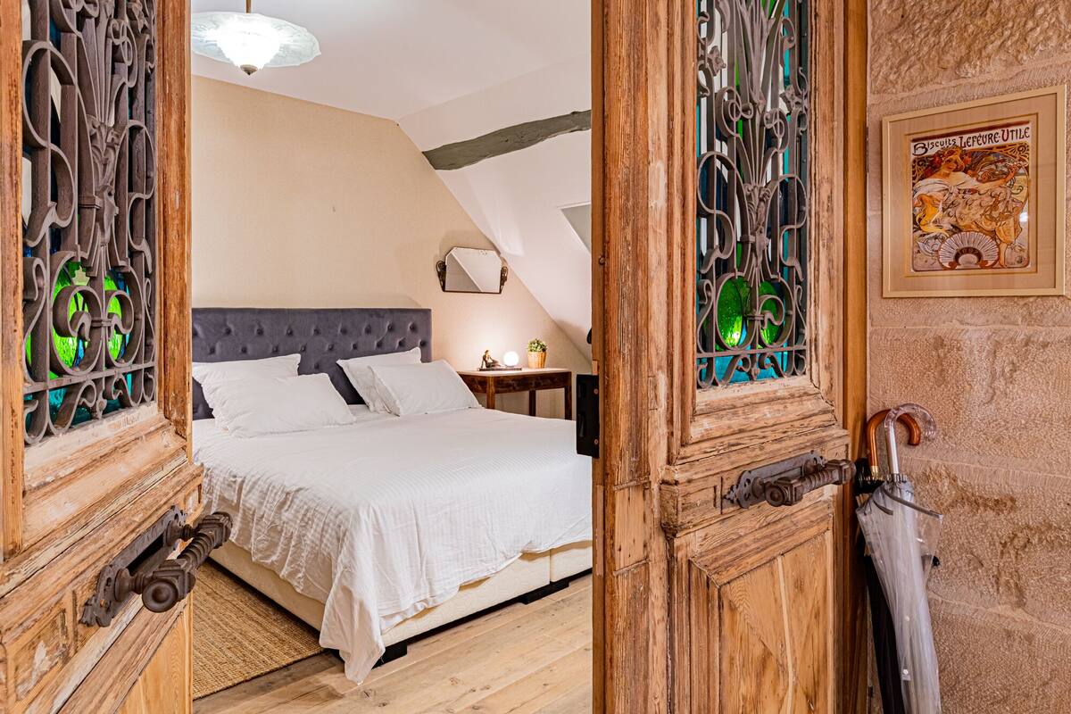 A bedroom with a bed, a nightstand, a lamp, and a framed picture on the wall.