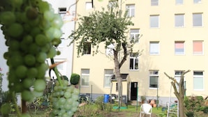 Un edificio residencial con un jardín delantero.