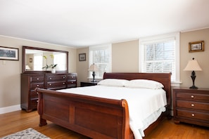 A bedroom with a wooden bed, a dresser, a nightstand, and a lamp. - Entire House:14 Guests, 7 BRs, 10 Beds, 5 Full Baths, Outdoor Shower, Beach Gear (Narragansett Pier)