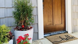 Une maison avec une porte en bois, une plaque portant le numéro 701 et un paillasson.