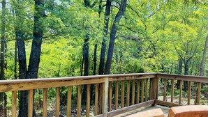 Une terrasse en bois avec vue sur une forêt.