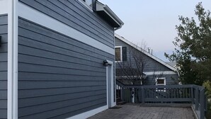 A residential building with a garage, a brick driveway, and a wooden fence. - Moose Lodge Loft at Rigden Farms (Fort Collins)