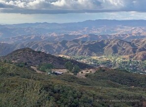 A mountainous landscape with a small settlement and a few buildings. - Cozy Mallard RV. Light, bright and inspiring trailer amongst the Pine trees. (Topanga)