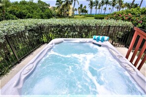Un jacuzzi con vistas al océano y palmeras.