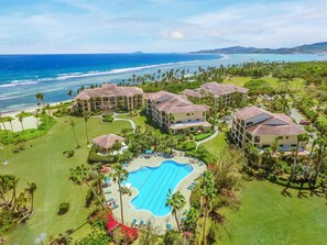 Un resort con varias construcciones, piscina y vista al mar.