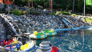 A water park with inflatable rafts, a pool, and a rocky waterfall. - Four-season lakefront charm in Northern Michigan (Harbor Springs)