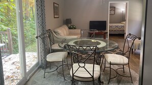 A cozy living room with a glass-top coffee table surrounded by chairs, a sofa, and a television. - 2Bedroom, 1.5Bath Cottage at Beautiful Wood Creek Lake,  Near Wood creek Marina. (London)