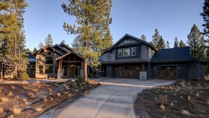 A modern two-story house with a large driveway, surrounded by trees and a landscaped garden. - Northwest Luxury with Access to Exclusive Golf (Sunriver)