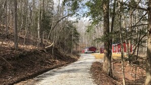 A gravel road leading to a red cabin in a forested area. - Peaceful 2Bedroom, 1.5Bath Cottage near Wood Creek Boat Dock (London)