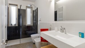 A modern bathroom with a glass shower enclosure, a white sink, and a large mirror. - GuestHost - ⋆Inner City Suite⋆ a stone's throw from Piazza S.Oronzo! (Lecce)