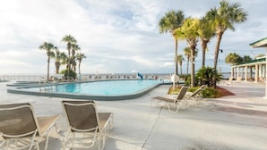 A pool area with lounge chairs and palm trees.