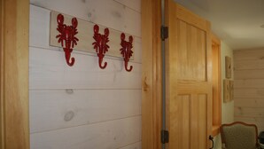 En vägg av trä med tre röda, dekorativa detaljer och en trädörr.