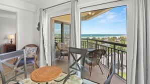 A balcony with wicker chairs, a glass table, and a view of the ocean. - 🌴 Gulf View Condo — Gulf Strand Resort, St. Pete Beach (St Pete Beach)