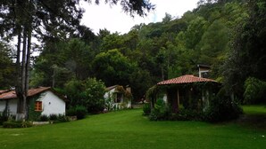 A serene garden with a white house and a small gazebo. - San Nicolás Rotamundos (San Cristóbal de las Casas)