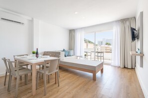 A modern, well-lit room with a dining table, chairs, a sofa, and a large window with curtains. - MASSANET (2C) - Luminous and modern apartment with a terrace, located just 250 meters from (Canyamel)