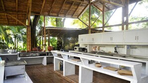 A spacious outdoor kitchen with a long counter, white cabinets, and a tiled floor. - Complete house with lush vegetation, hot water Jacuzzi for 12 people (Santagueda Palestina Caldas)