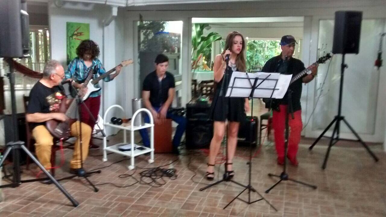 A group of people performing music with instruments and a music stand.