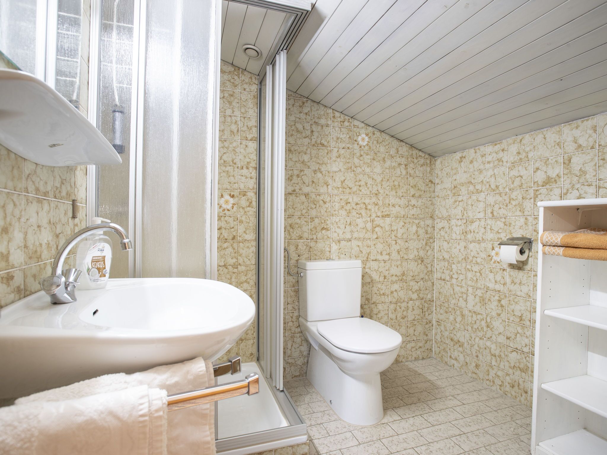 A bathroom with a sink, toilet, and shower.