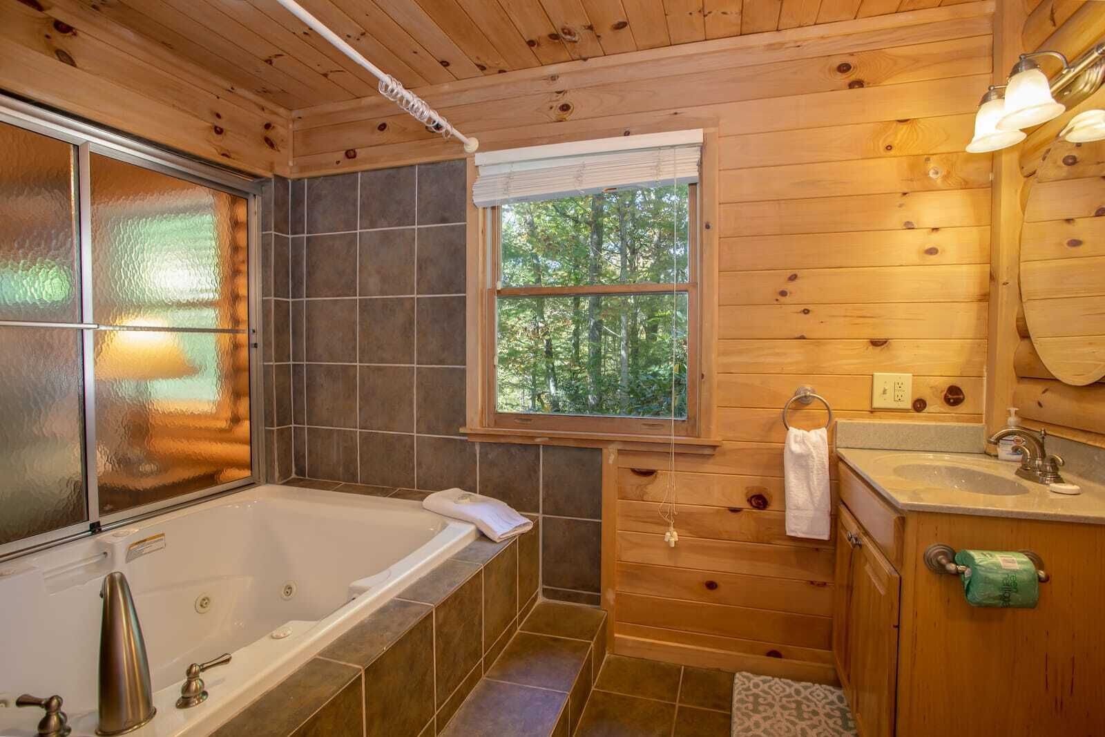 Een bad/douchecombinatie, een bubbelbad, handdoeken