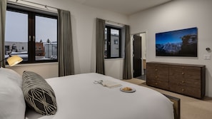 Une chambre d’hôtel avec un lit, une commode, une fenêtre avec des rideaux, une lampe et un tableau au mur.