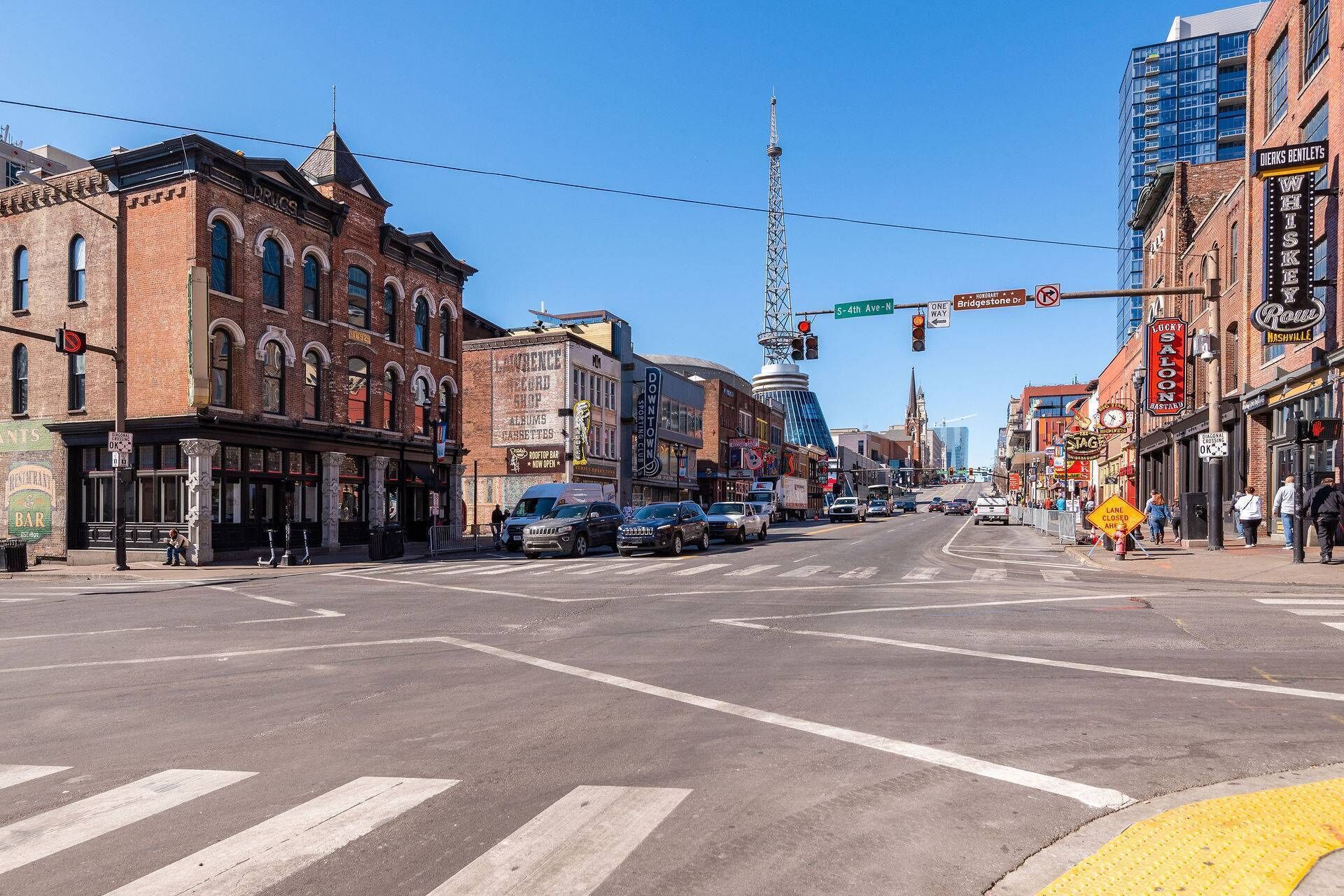 Un cruce de calles con edificios históricos, una torre destacada y diversos comercios.