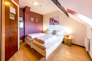 Cozy retreat with a large bed, bedside table, and radiator.