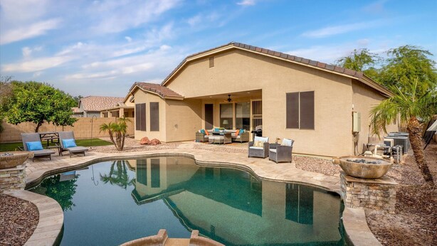 A house with a swimming pool, outdoor furniture, and a patio area. - 4-BR Home with a Private Heated Pool (Litchfield Park)