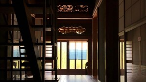 A traditional Japanese interior with a wooden floor, sliding doors, and a staircase. - Shimanto Riverside Hideaway (Shimanto)