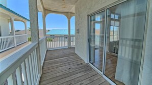 A wooden deck with a glass door leading to a room.