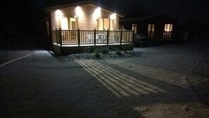 A house with a wooden deck and a snow-covered driveway. - Luxury 2 Bedroom Lodge (sleeps 5) (North Runcton)
