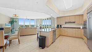 Une cuisine moderne dotée d’un grand îlot central, de meubles en bois et d’appareils électroménagers en acier inoxydable.